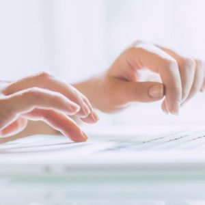 Close of lady hands typing on white keyboard