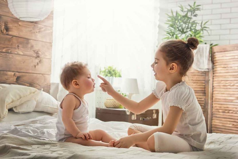 sibling touching baby's face