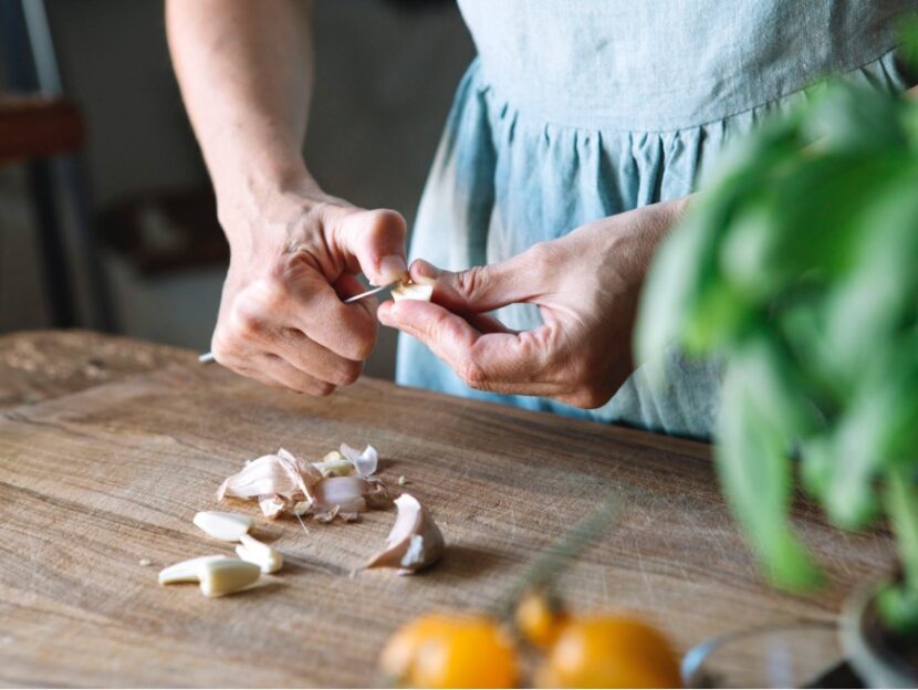 Hands cutting garlic