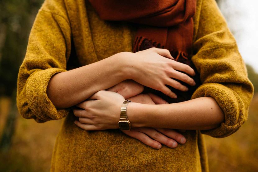 woman in yellow jumper being hugged